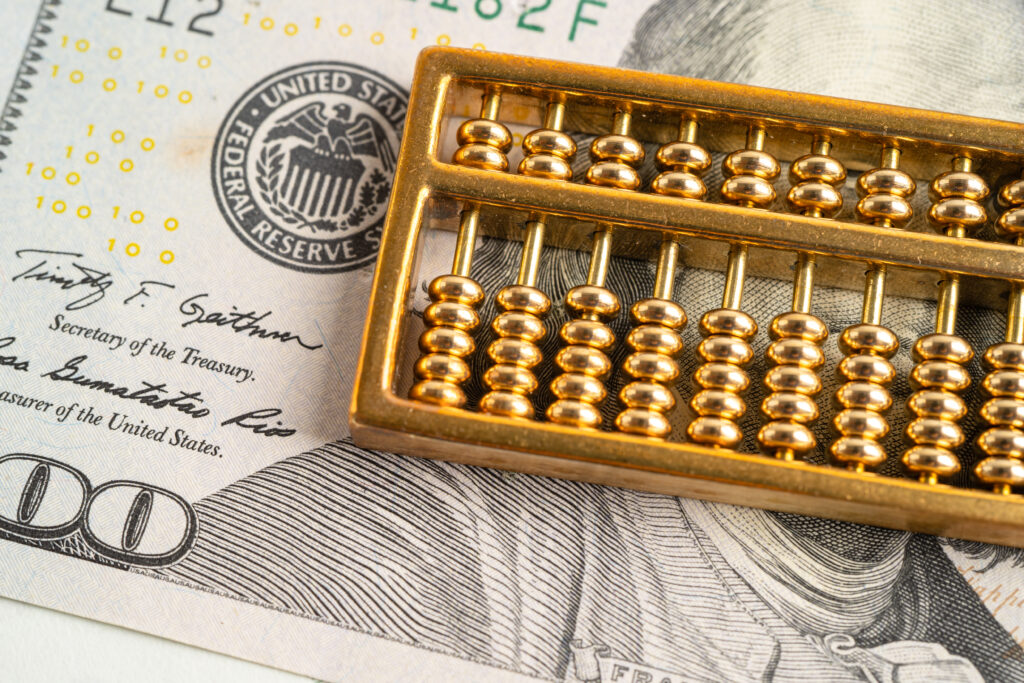 Złote liczydło na banknocie dolara amerykańskiego - pieniądze, gospodarka, finanse