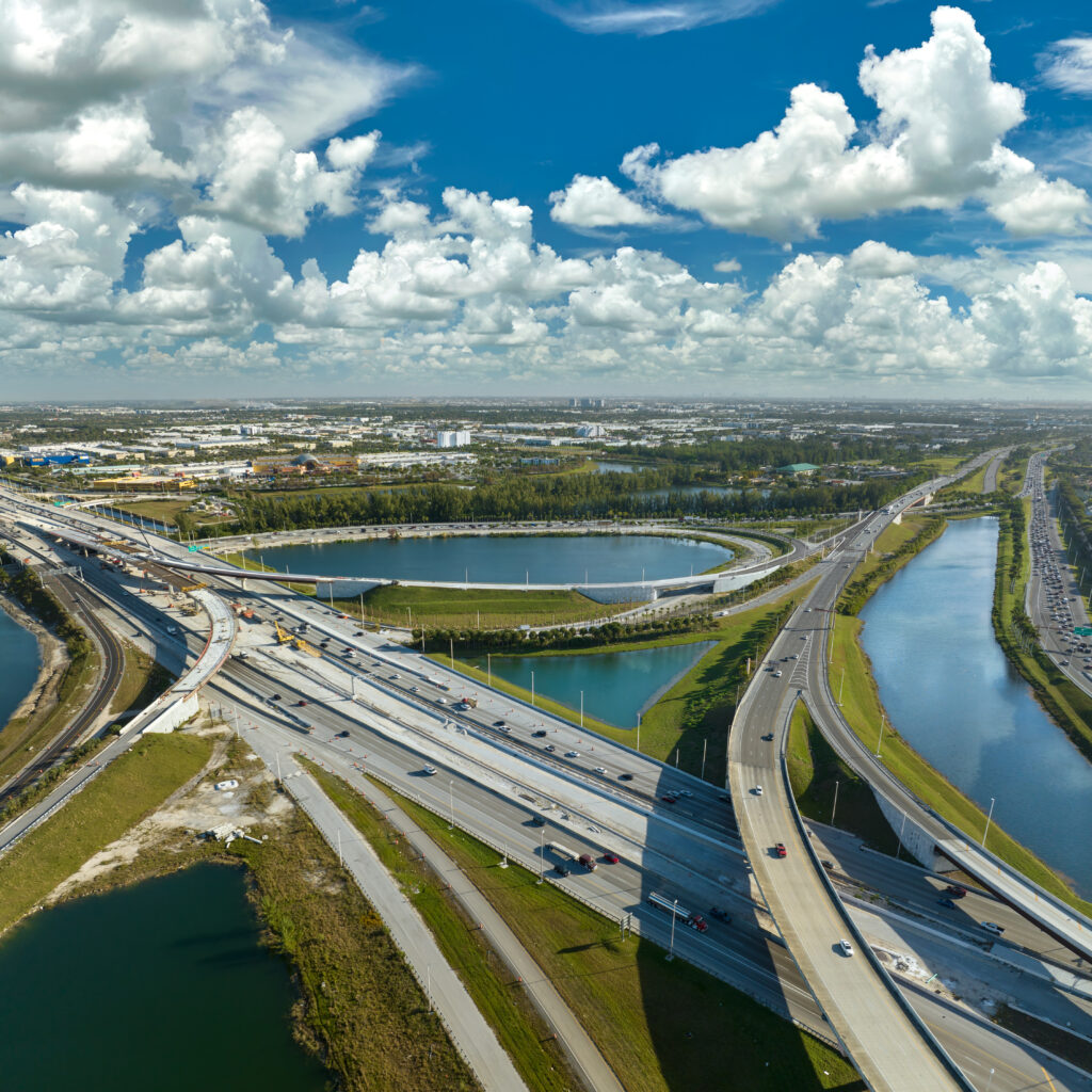 Koncepcja infrastruktury transportowej USA. Widok z góry na duże amerykańskie skrzyżowanie autostrad w Miami na Florydzie z szybko poruszającymi się samochodami i ciężarówkami.