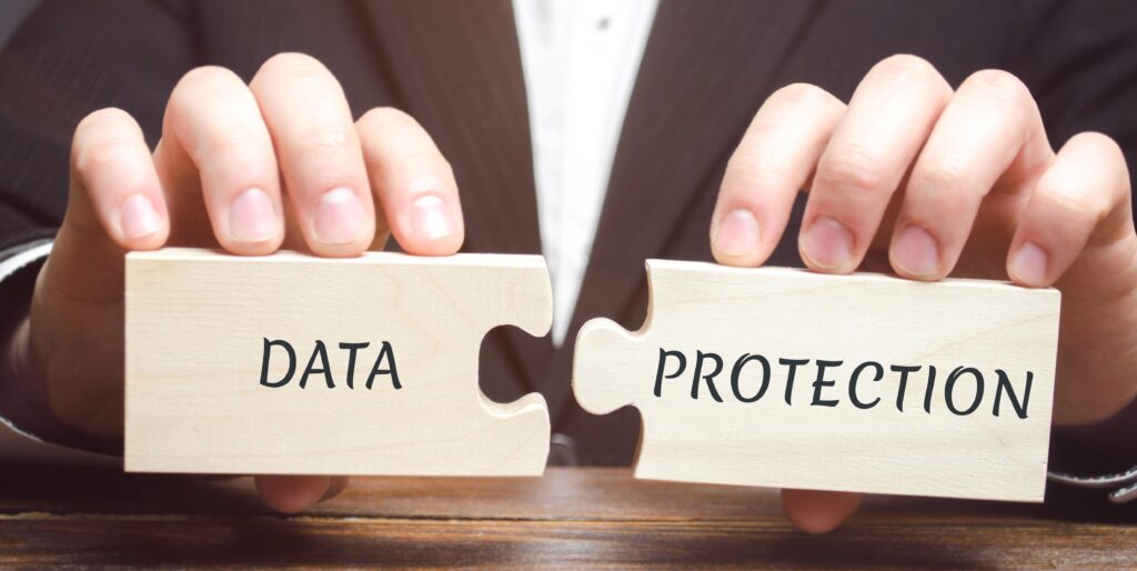 Biznesmen zbiera drewniane puzzle z napisem Data Protection. Odmowa dostępu do poufnych informacji. Zapewnienie poufności danych osobowych i biznesowych. RODO. Cyberbezpieczeństwo