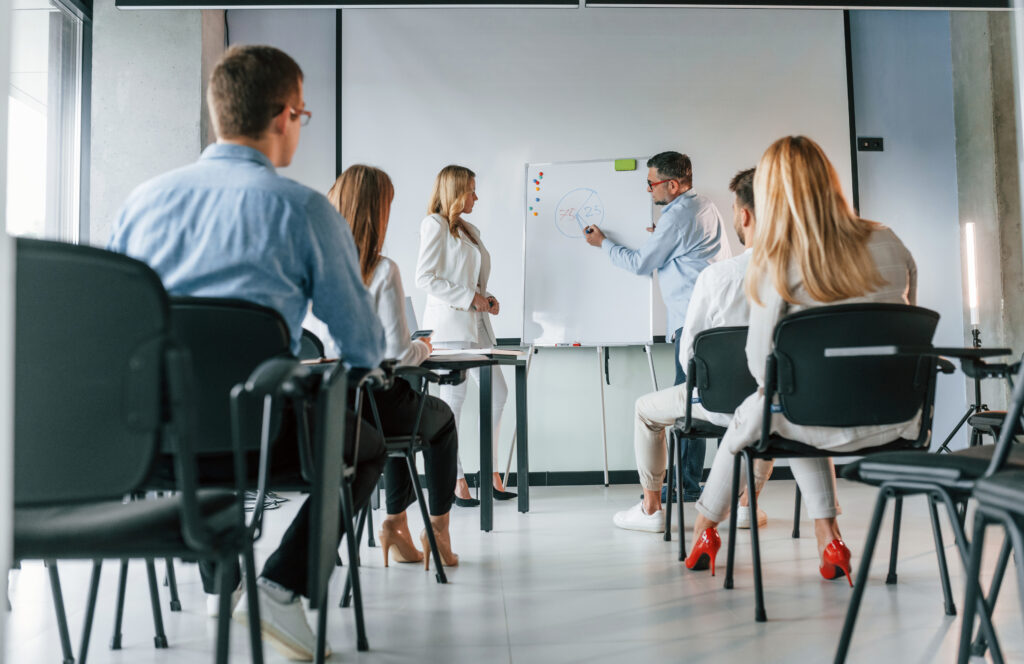 Nauczyciele prowadzący klasę mistrzowską. Grupa profesjonalnych biznesmenów jest w biurze.