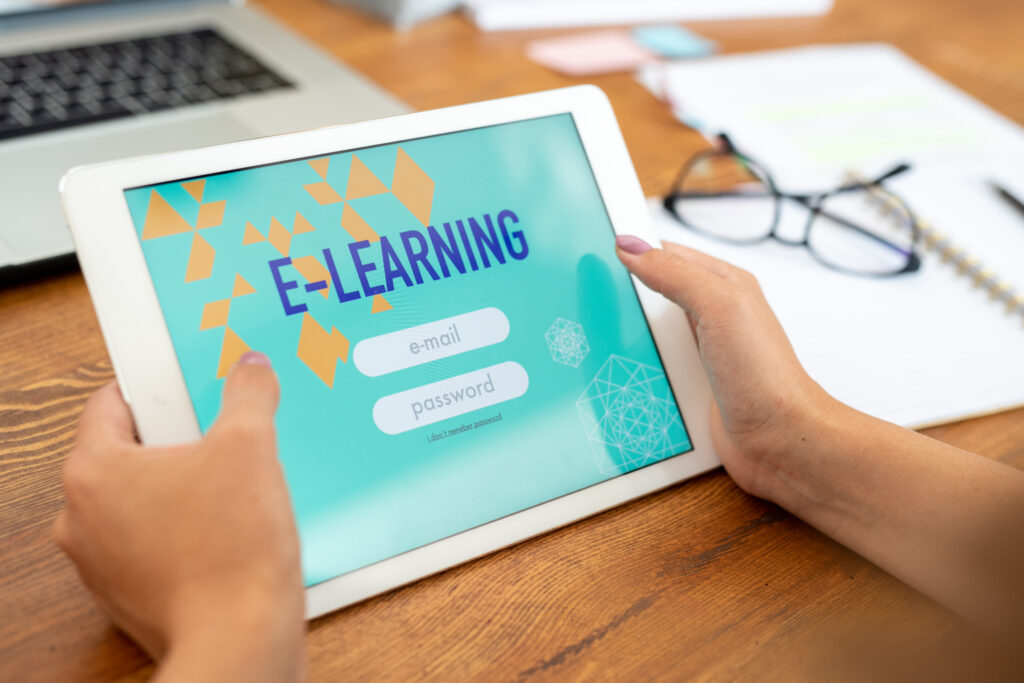 Touchpad trzymany przez młodą studentkę edukacyjnej strony internetowej przed wprowadzeniem adresu e-mail i hasła w celu wejścia do systemu