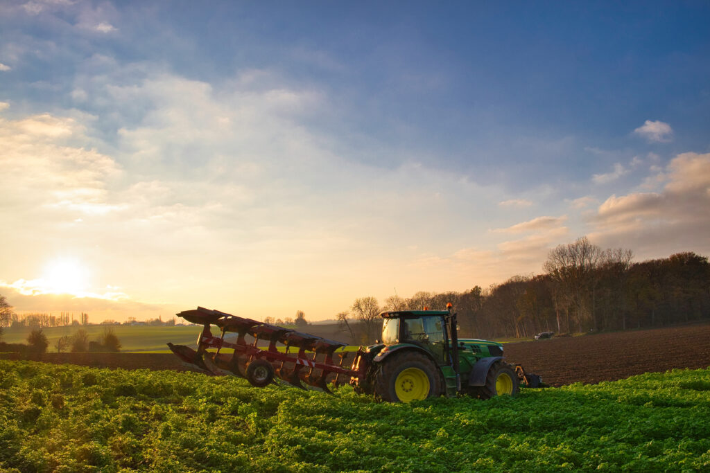 Traktor na malowniczym polu rolnym w Sunris, rolnictwo w Maransart, Lasne, Belgia